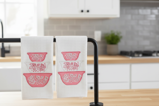 Pink gooseberry embroidered kitchen towels folded and hanging in kitchen